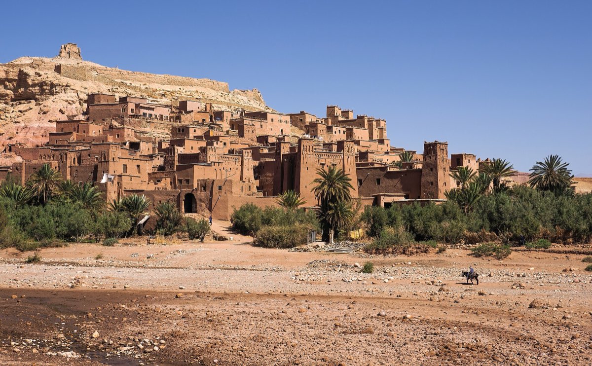 The earthen ksar of Aït Benhaddou climbing a hill above a river bed