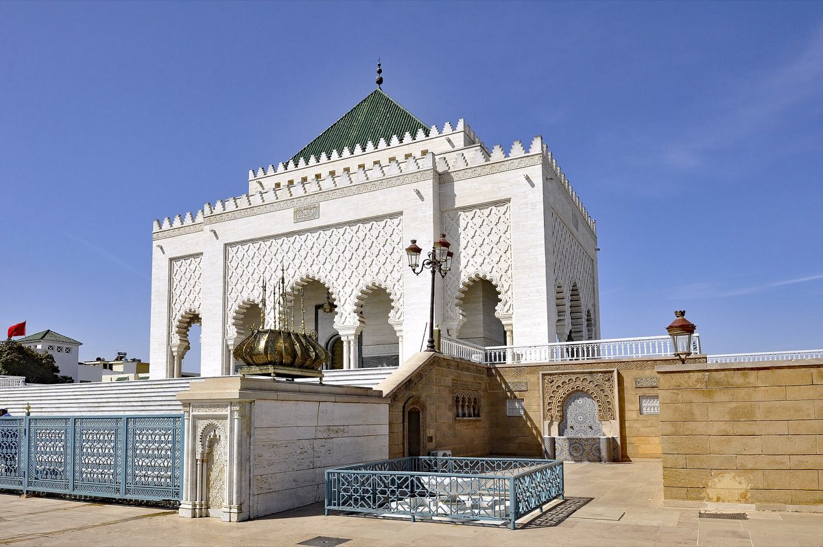 The white Mausoleum of Mohammed V with a green tiled roof